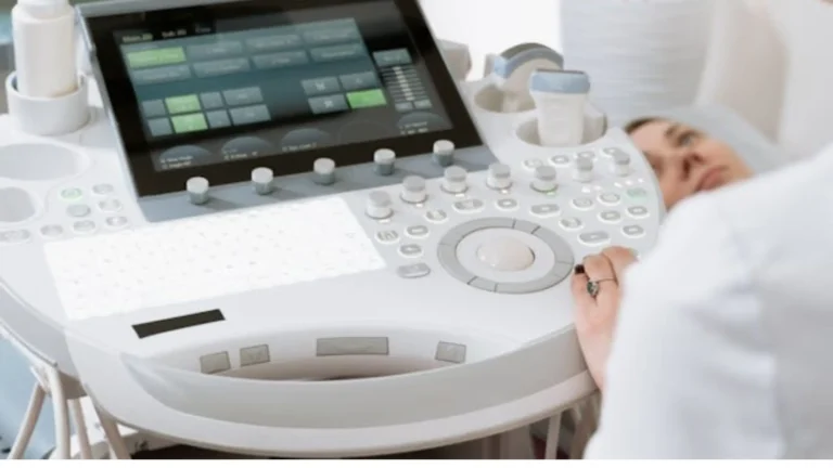 A close-up of a medical ultrasound machine being used to monitor a patient's pregnancy, representing specialized perinatal care and fertility treatments provided by a female gynecologist.