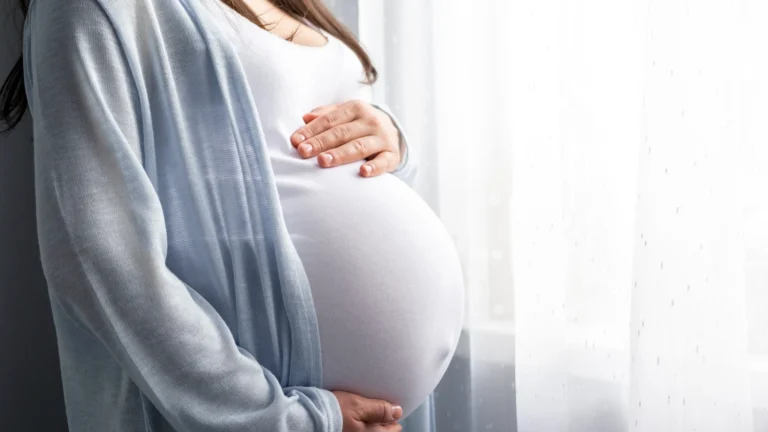 A female gynecologist performing a prenatal check-up on a pregnant woman, emphasizing specialized care and monitoring for both routine and high-risk pregnancies.